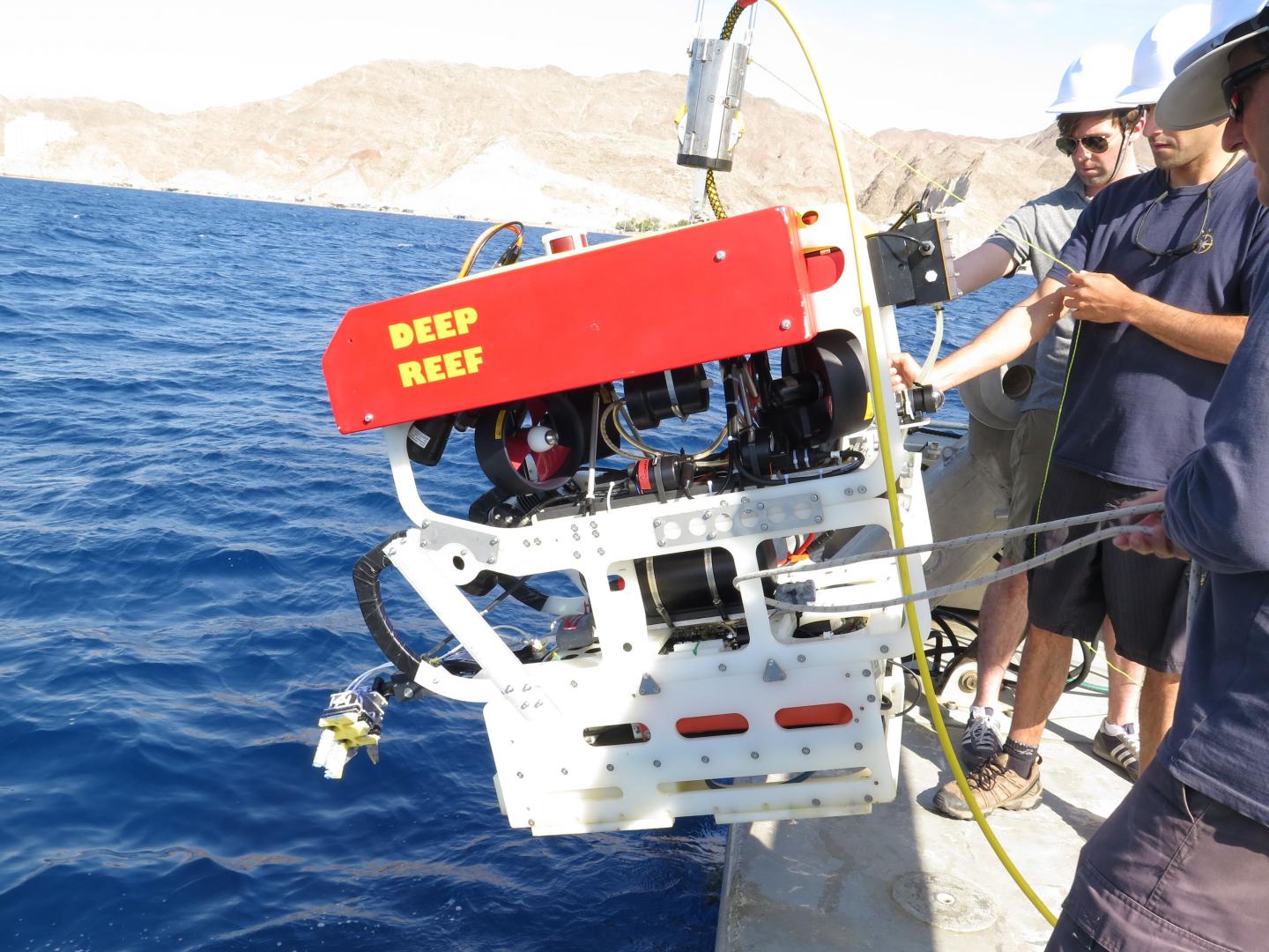 Soft robotic gripper is attached (lower left) to the remotely operated vehicle (ROV) as it is lowered into the Red Sea for a test dive. (Image Credit: Kevin Galloway, Wyss Institute, Harvard University)