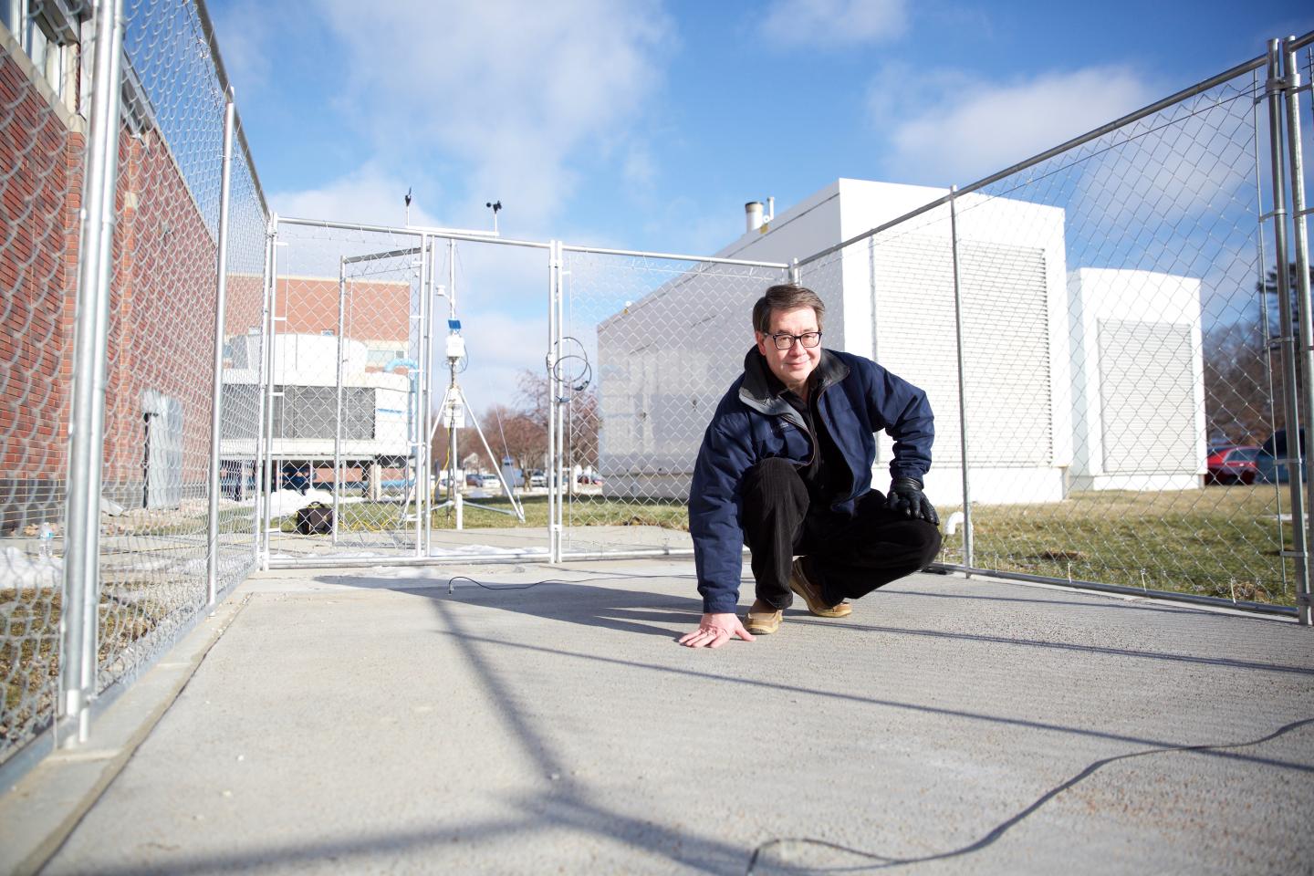 Professor Chris Tuan stands on a slab of conductive concrete that can carry enough electrical current to melt ice during winter storms. (Image Credit: Scott Schrage /UNL)