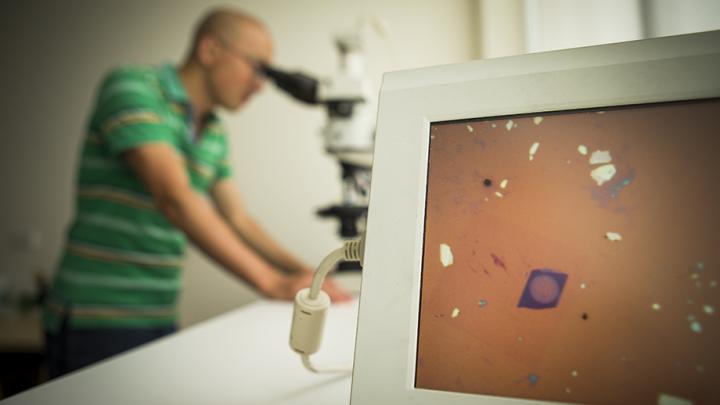 ANU researchers examine the lens (purple circle on screen). (Image Credit: Stuart Hay/ANU)