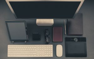 a high-tech desk with keyboard, tablet, monitor, mouse, and other smart tech and computer accessories